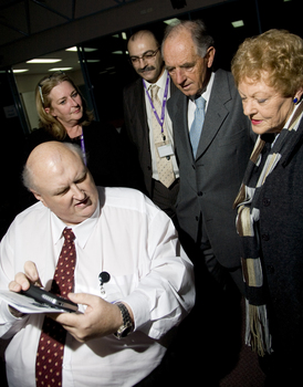 Jim Pipczak demonstrating a Nokia screen reader to John and Nancye Cain, with Julie Rae and Tony Iezzi looking on
