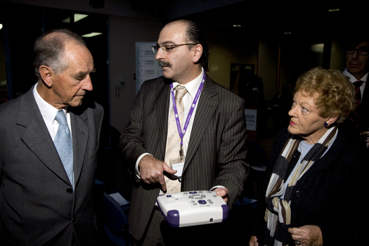 Tony Iezzi demonstrating a Daisy player and book to John and Nancye Cain