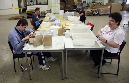 Workers around a table packing items