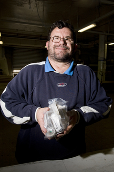 Man holding packed items as he looks to camera