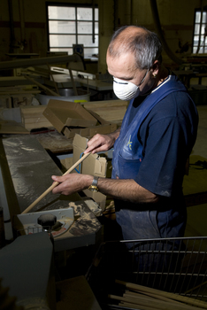 Man wearing a dust mask holding a dowel