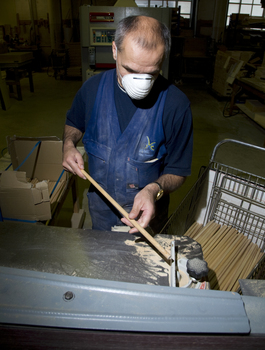 Man wearing a dust mask holding a dowel