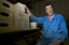 Man touches a small tower of wooden boxes