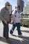 White cane user walking along river path at Southbank on a sunny day