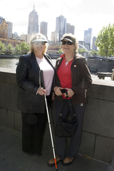 White cane user on the bridge at Southbank on a sunny day