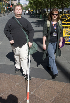 White cane users walking along river path at Southbank on a sunny day
