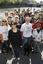 Group of people holding white canes or holding dogs pose beside Yarra River and Princess Bridge