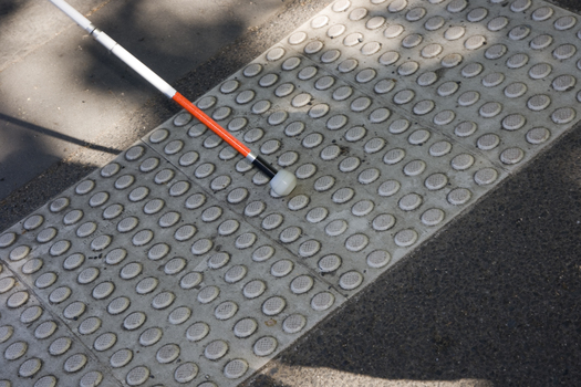 White cane and ball touching the tactile marker at the crossing