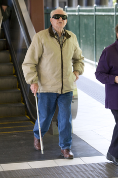 White cane user walking along the platform at Flinders Street Station