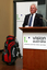 David Blyth speaking at the podium with his golf clubs beside him