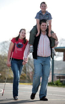 Tony Clarke with his son and daughter walking in a schoolyard