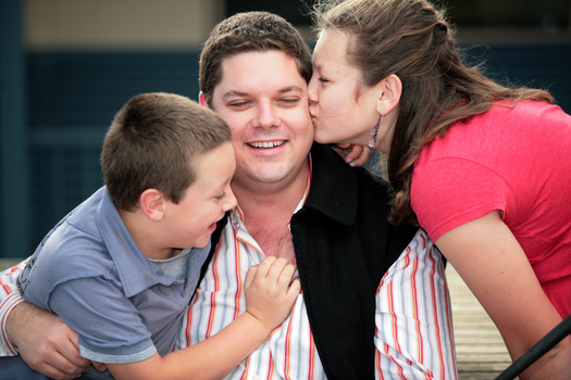 Tony Clarke getting a kiss from his son and daughter in a school yard