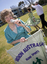 Margaret Fox with microphone and banner in front of square dancers at rear of Kooyong building