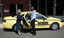Taxi driver assisting a woman with a white cane 