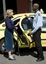 Taxi driver assisting a woman with a white cane 