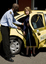 Taxi driver assisting a woman with a white cane 