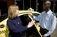Taxi driver assisting a woman with a white cane 