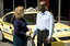 Taxi driver assisting a woman with a white cane 