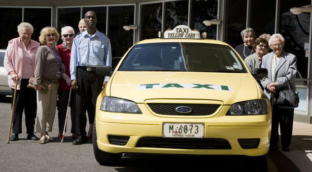 Taxi driver with a large group of women, some holding canes
