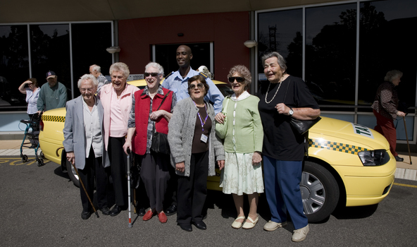 Taxi driver with a group of women, some holding canes