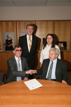 Dr Kevin Murfitt shaking hands with BCA person whilst Gerard Menses and Nadia Mattiazzo look on