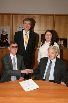 Dr Kevin Murfitt shaking hands with BCA person whilst Gerard Menses and Nadia Mattiazzo look on