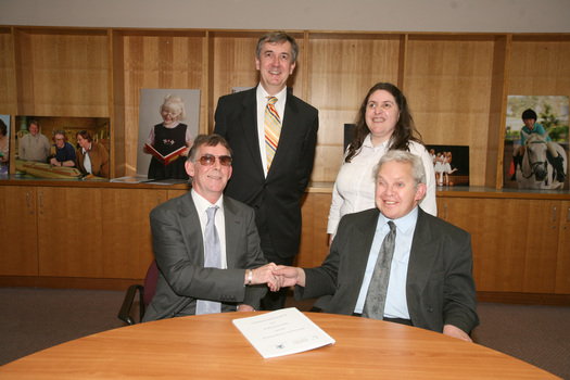 Dr Kevin Murfitt shaking hands with BCA person whilst Gerard Menses and Nadia Mattiazzo look on