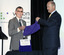 Kevin Murfitt and Nick Carter jointly raising a purple cloth from a wrapped plaque