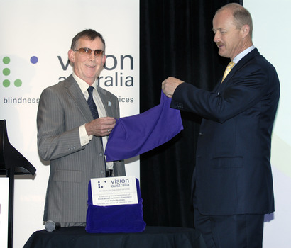 Kevin Murfitt and Nick Carter jointly raising a purple cloth from a wrapped plaque
