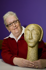 Woman with sculpture of head on long neck