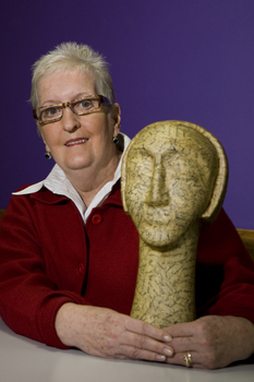 Woman with sculpture of head on long neck