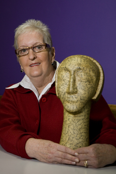 Woman with sculpture of head on long neck