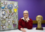 Woman with sculpture of head on long neck and mosaic of teacups