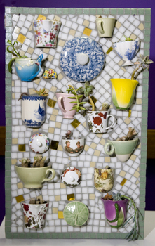 A mosaic of teacups, some containing plants