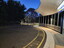 Looking down the driveway in the early morning, with light on building and car park
