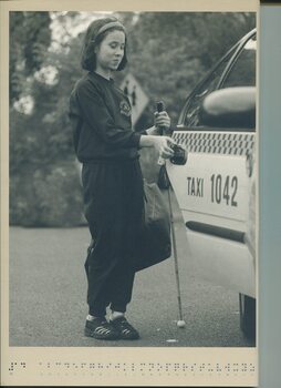 A girl with a cane reaches for the door of a taxi