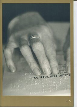 Fingers reading a Braille book
