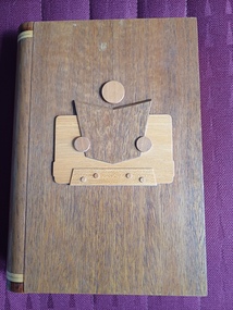 Wooden box with wooden figure holding book on front