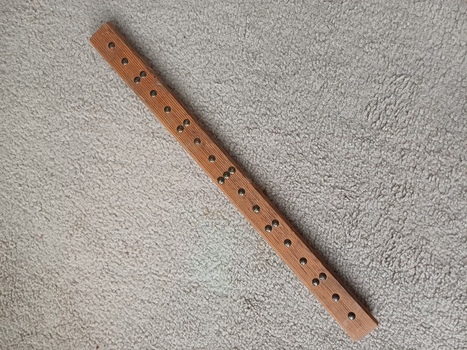 Wooden ruler with round metal pins as measurement points