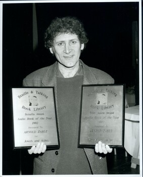 Arnold Zable with plaques for winning book Braille and Audio book of the Year