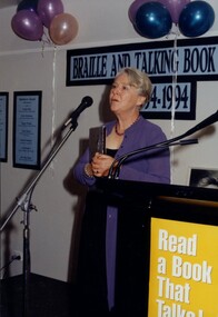 Unknown woman holding award at podium