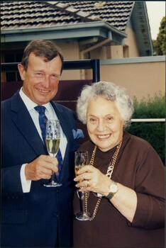 Man and woman holding champagne glasses as they smile for camera