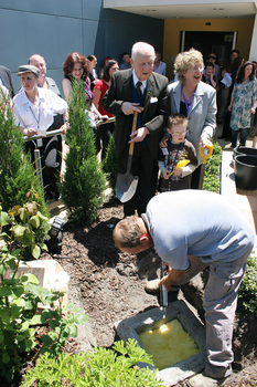 Reuben Ryan, Jarryd Clifford and Jennifer Gibbons watch the gardener caulk the covering plate, with Johanne and Anna Fairclough on left
