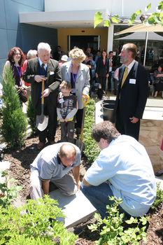 Reuben Ryan, Jarryd Clifford and Jennifer Gibbons watch the gardener caulk the covering plate with Peter North and Graeme Innes