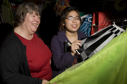 Two women feeling some of the costumes backstage at Wicked