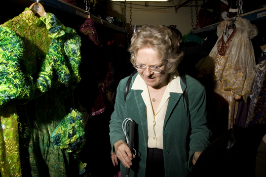 A woman amongst the costumes backstage at Wicked