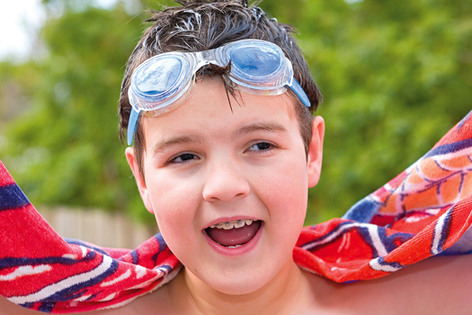 Nicholas Law wearing swimming goggles and holding a beach towel