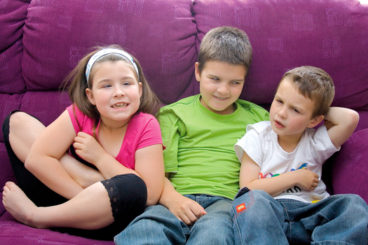 The three Law children sitting on a purple couch