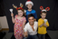 Kate, Nicholas and Jacob Law with Anthony Callea holding candles and wearing Christmas hats