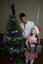 Kate Law with Anthony Callea holding a present next to a Christmas tree